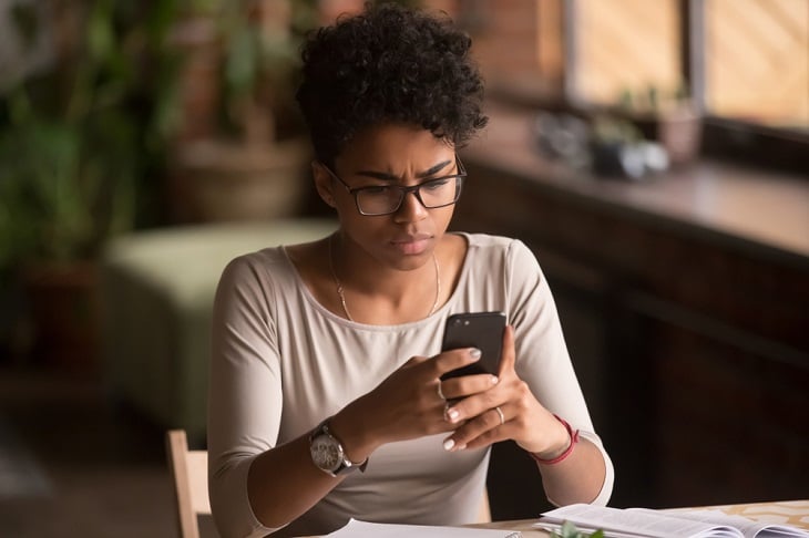 Young woman looking at unknown number phone