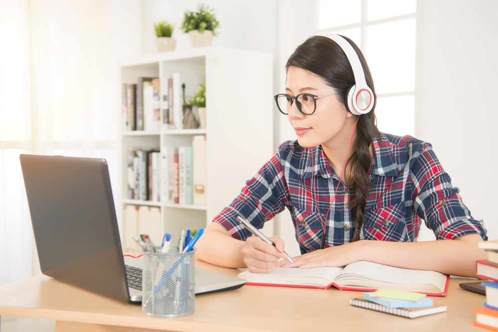 Girl listening to music and writing