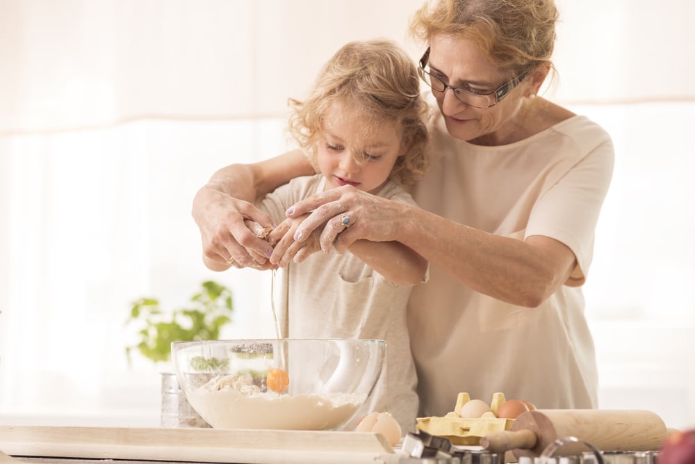 Senior woman baking with little girl