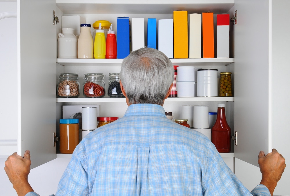 Senior man looking in food cupboard