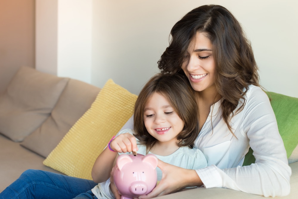 Mother and daughter with a piggy bank