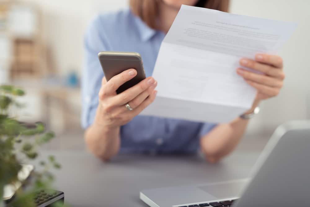 Woman looking at phone bill