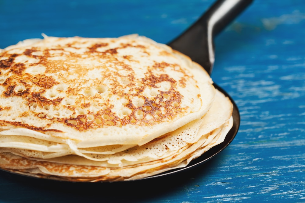 Stack of crepe pancakes in frying pan