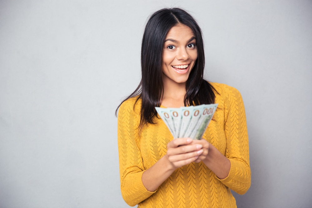 Excited woman holding cash