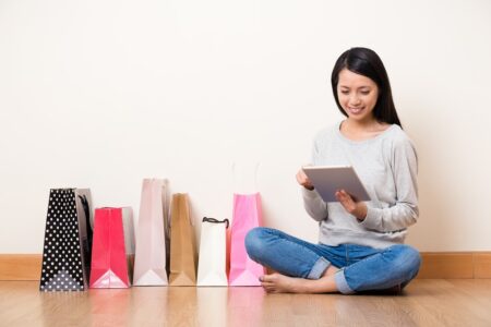 Woman with shopping bags using a tablet